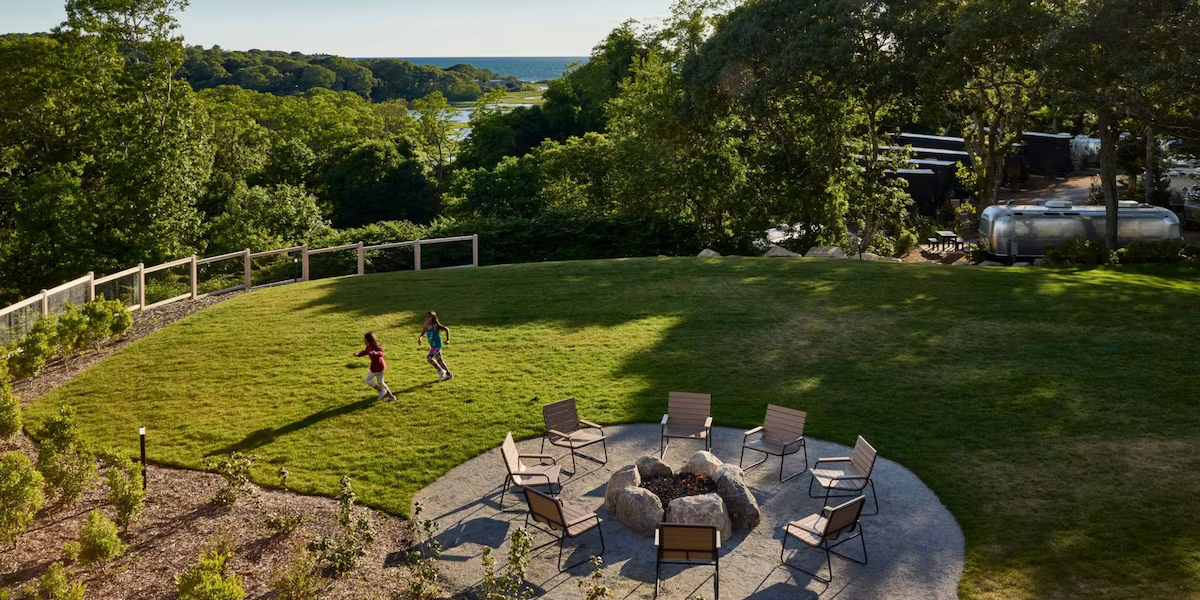The lawn, stone fire pit and ocean view at Cape Cod Auto Camp