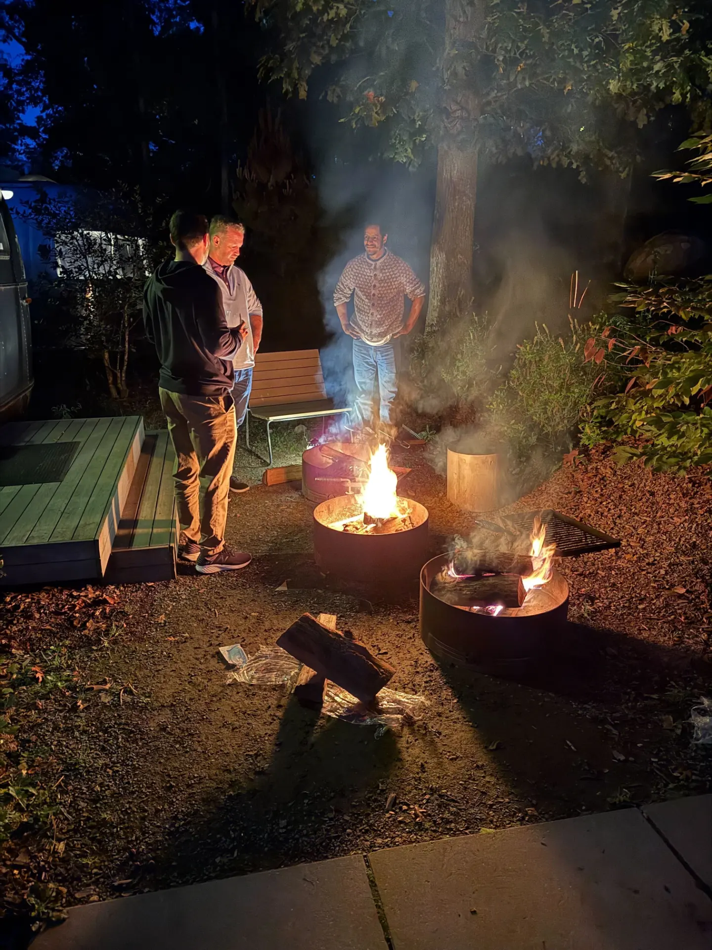 Fire pits glowing at dusk at the offsite grounds