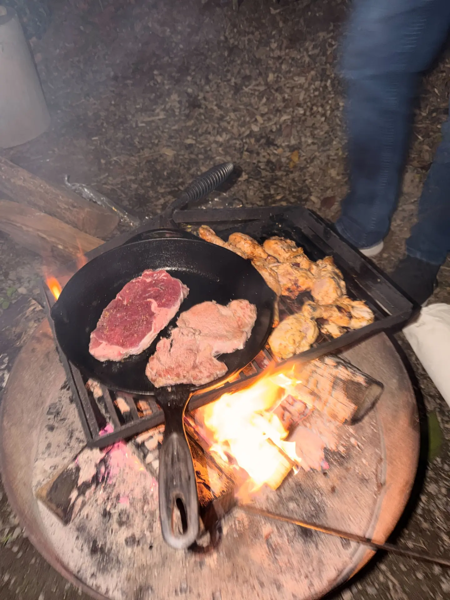 Steaks and chicken grilling over the open fire