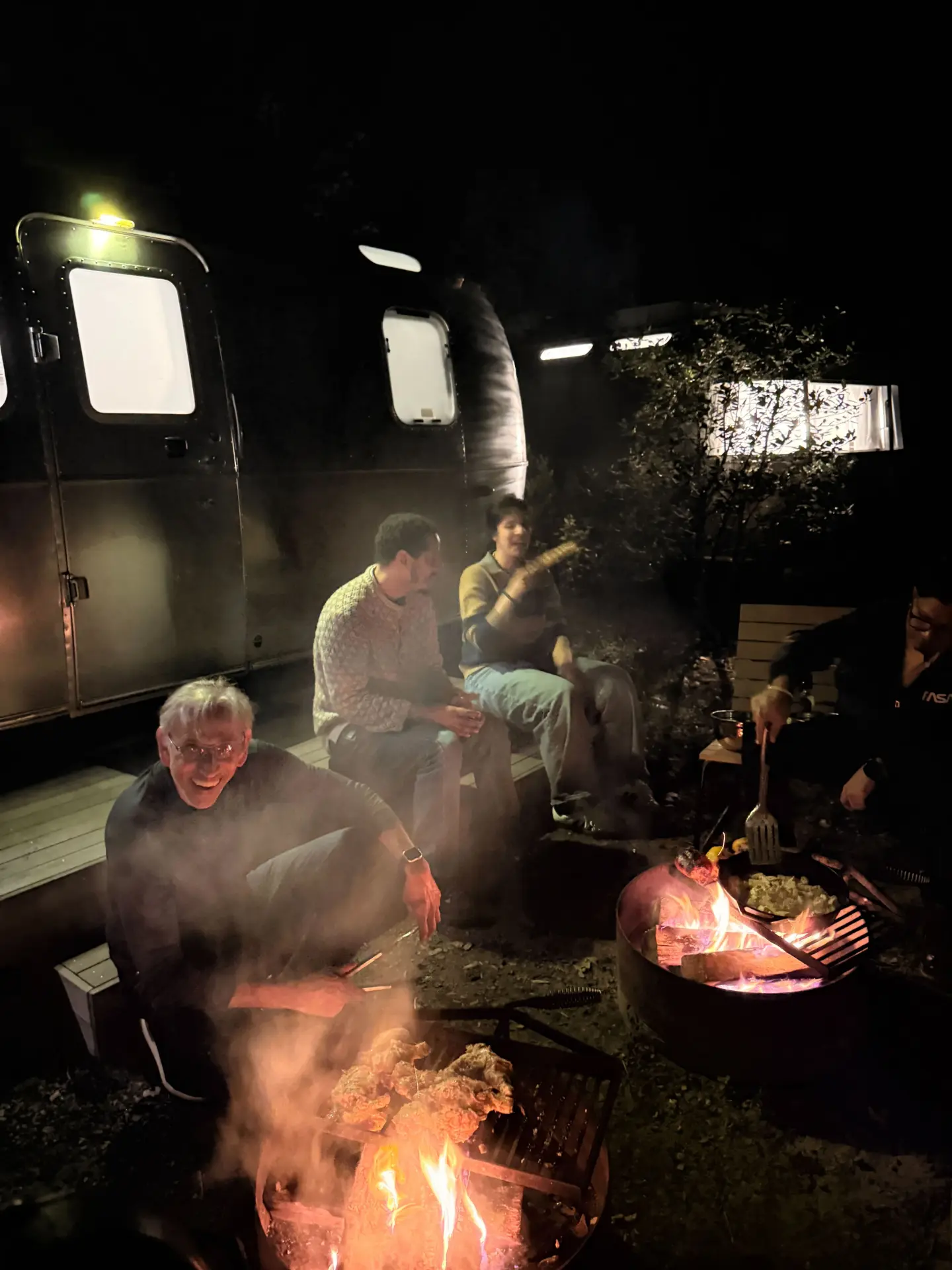 The team laughing around the campfire at night